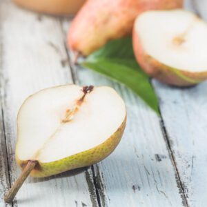 A pear cut in half on a table.