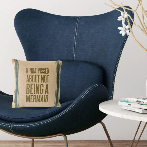 A blue chair with a pillow that says, i'm not worried about being a mermaid.