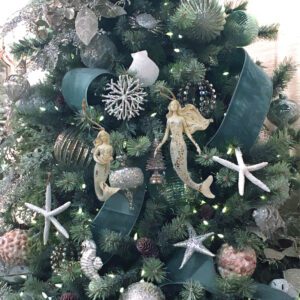 A christmas tree decorated with mermaid ornaments.