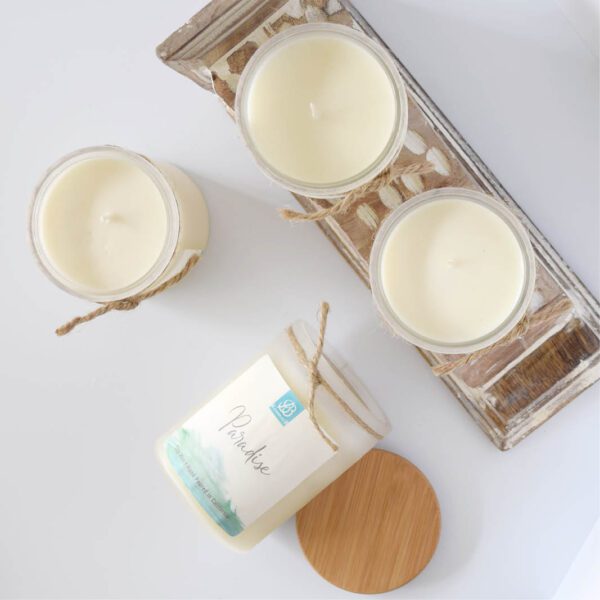 Three candles on a wooden tray.