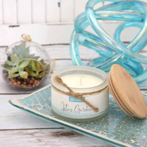 A candle with a wooden lid on a tray.