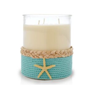 A candle with a starfish and rope on it.