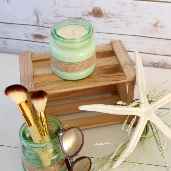 A wooden crate with a candle, brushes, and a starfish.