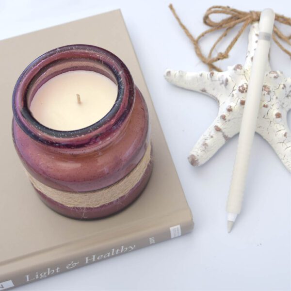 A candle sits next to a book and a starfish.