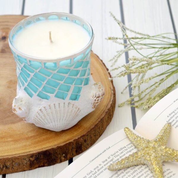 A candle is sitting on a wooden board next to a book.