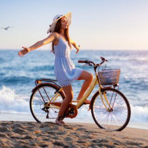 A woman is riding a bicycle on the beach.