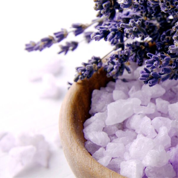 Lavender salt in a wooden bowl on a white background.