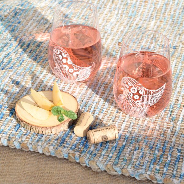 Two hand-painted Le Blanc wine glasses on a table with cheese and crackers.