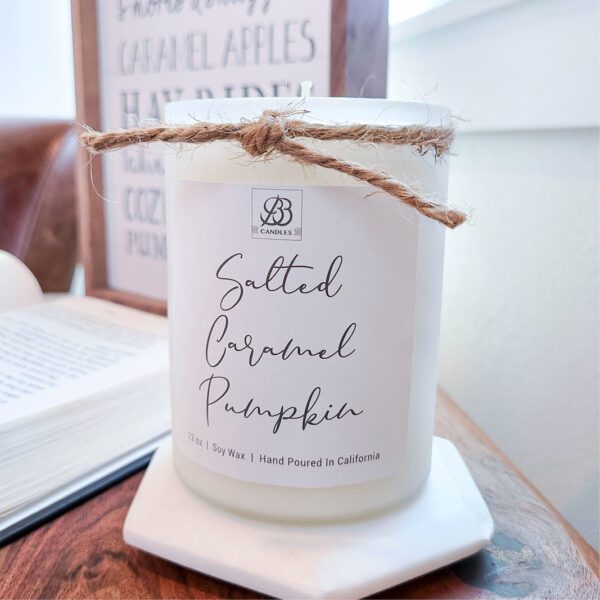 A candle is sitting on a table next to a book.