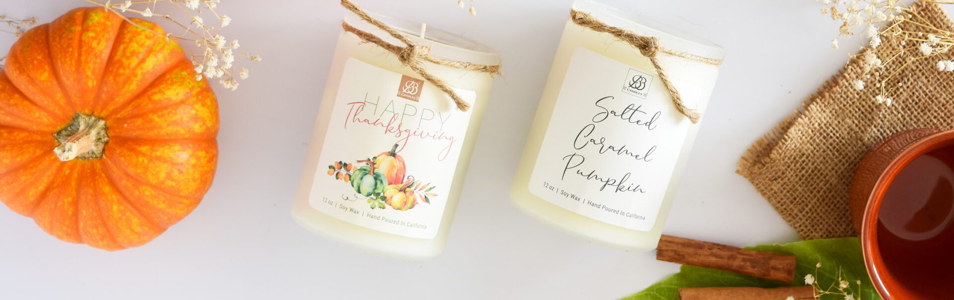 Scented candles with pumpkins and spices on a table, perfect for home decor.