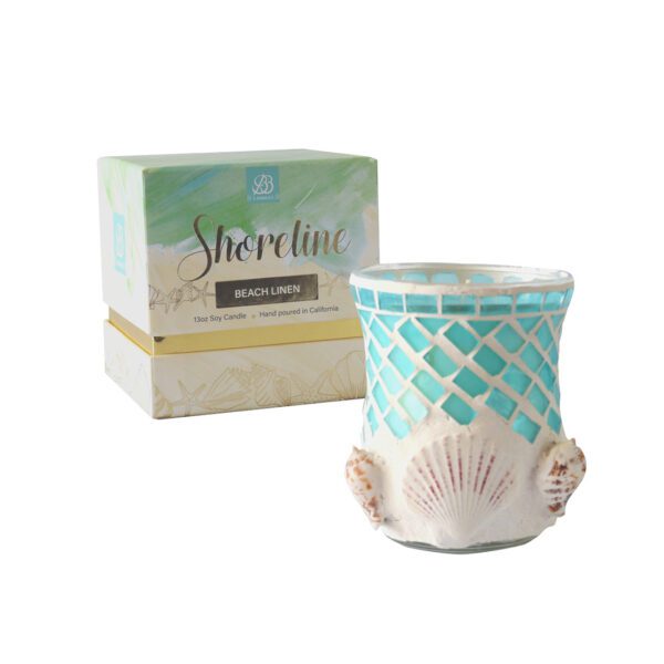 A candle with shells on it next to a box.