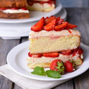 A slice of cake with strawberries on a plate.