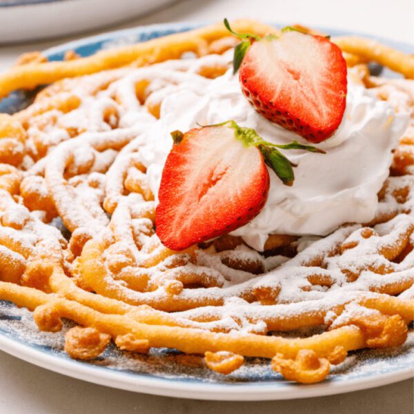 A plate of waffles with whipped cream and strawberries.