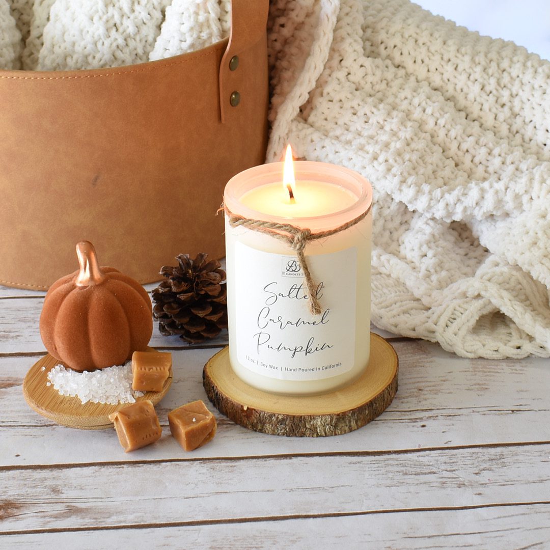 A scented candle rests on a wooden table beside a basket, adding to the cozy home decor ambience.