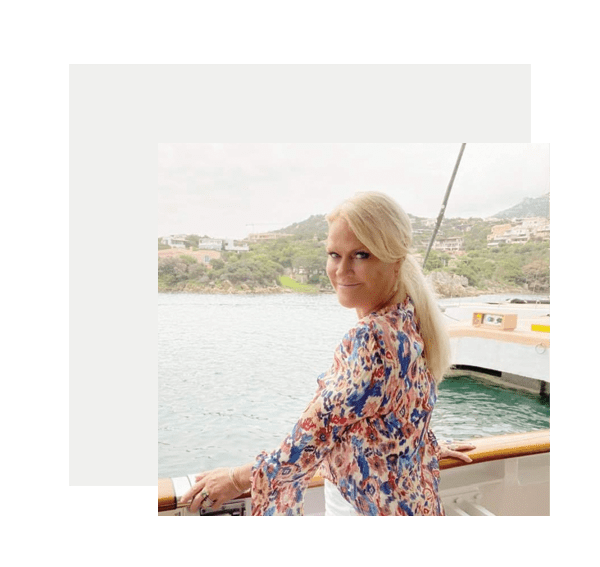 A blonde woman standing on the deck of a boat.